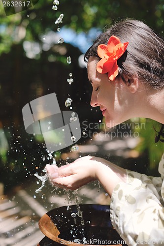 Image of splashing fresh water on woman hands