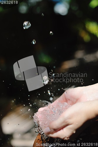 Image of splashing fresh water on woman hands