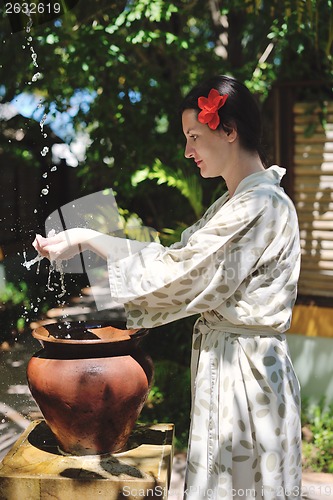 Image of splashing fresh water on woman hands