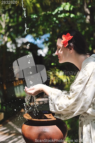 Image of splashing fresh water on woman hands