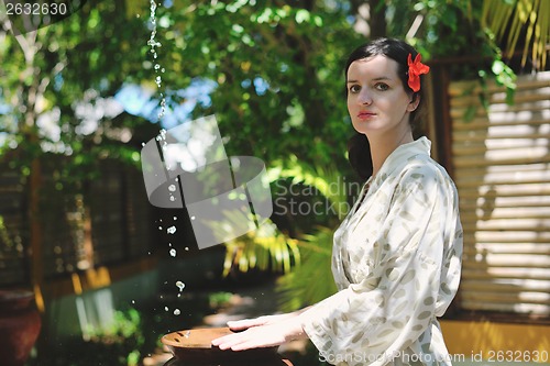 Image of splashing fresh water on woman hands