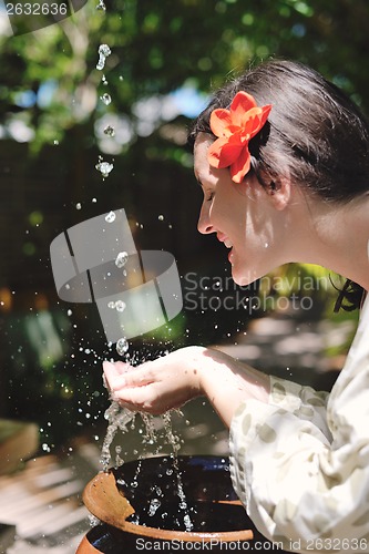 Image of splashing fresh water on woman hands