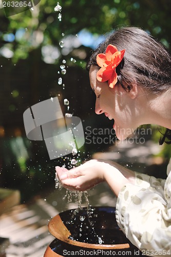 Image of splashing fresh water on woman hands