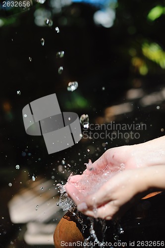 Image of splashing fresh water on woman hands