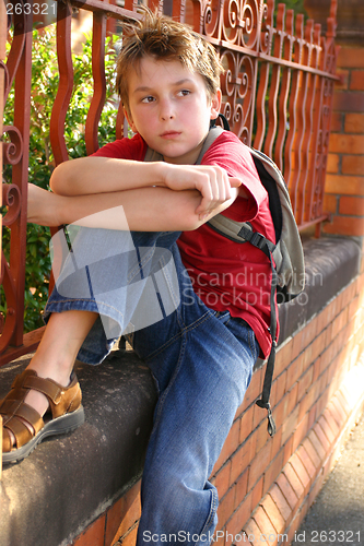 Image of Boy with schoolbag slung over shoulder