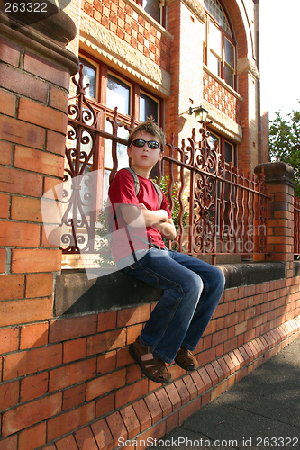 Image of Child sitting on brick wall