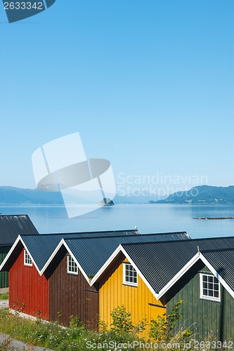 Image of Colorful camping cabins on the fjord shore