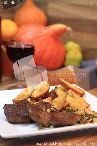 Image of beef steaks with potatoes and wine