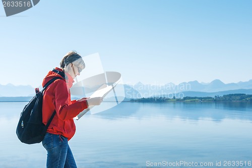 Image of Woman tourist reading the map, traveling in Norway