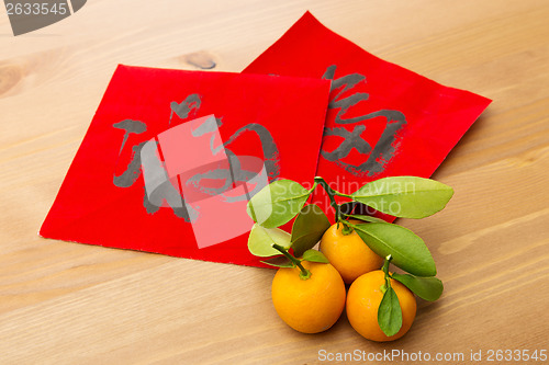Image of Chinese new year calligraphy and kumquat, word meaning is good l