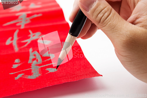 Image of Writing of chinese new year calligraphy, phrase meaning is happy