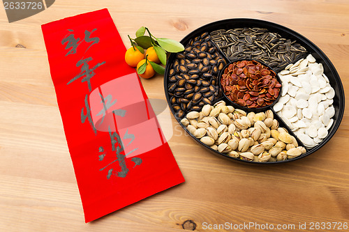 Image of Chinese new year snack tray and chinese calligraphy, meaning for