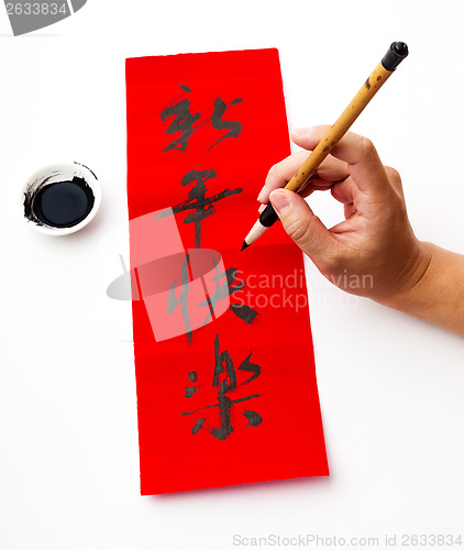 Image of Writing of chinese new year calligraphy, phrase meaning is happy