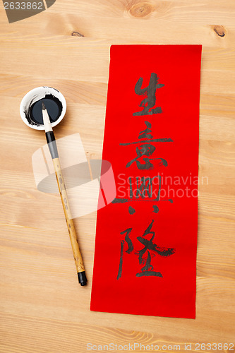 Image of Writing of chinese new year calligraphy, phrase meaning is busin