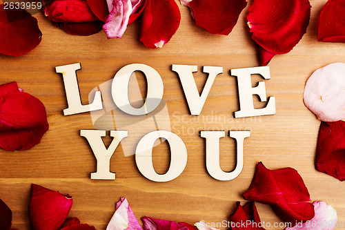 Image of Love you wooden text and rose petal