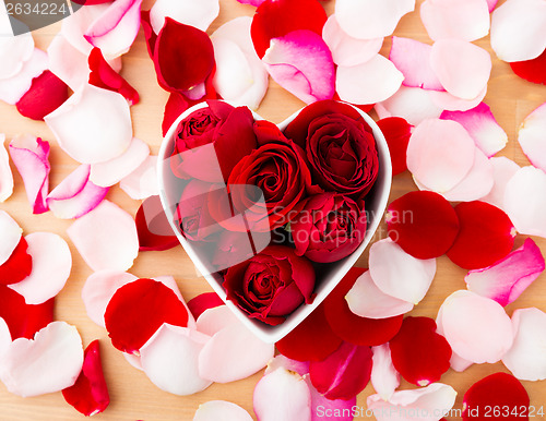 Image of Rose inside heart shape bowl with petal beside 