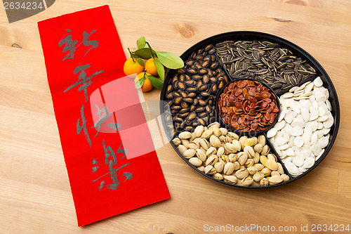 Image of Lunar new year snack tray and chinese calligraphy, meaning is ha