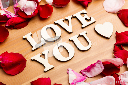 Image of Love You wooden letters with rose petal besides