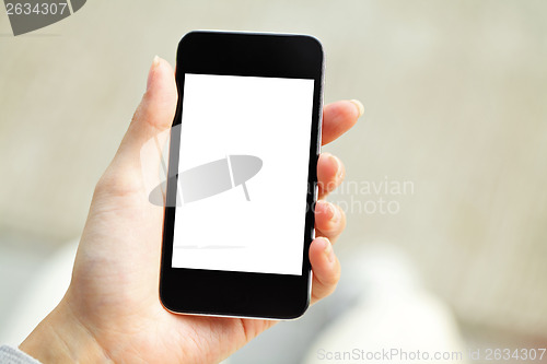 Image of Hand holding mobile phone with blank screen