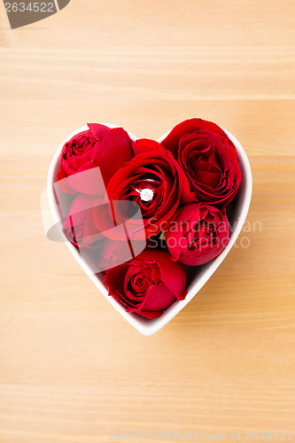Image of Red rose and diamond ring inside heart shape bowl 
