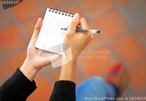 Image of Woman hand jot note