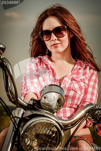 Image of Biker girl sitting on motorcycle