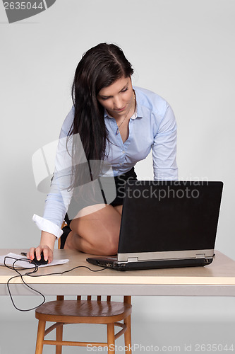 Image of Female poses behind a desk in the office