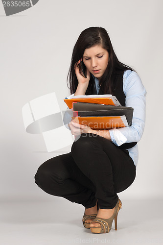 Image of Young woman is squatting and phone