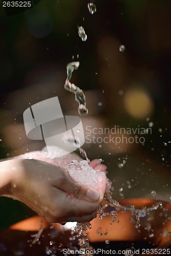 Image of splashing fresh water on woman hands