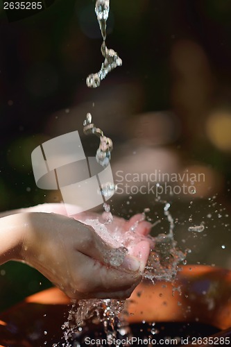 Image of splashing fresh water on woman hands