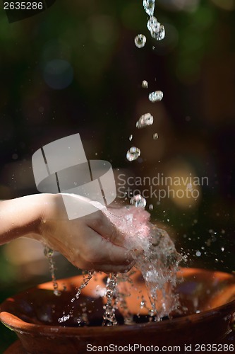 Image of splashing fresh water on woman hands