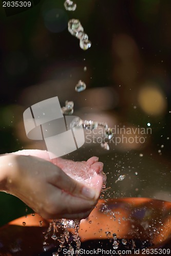 Image of splashing fresh water on woman hands