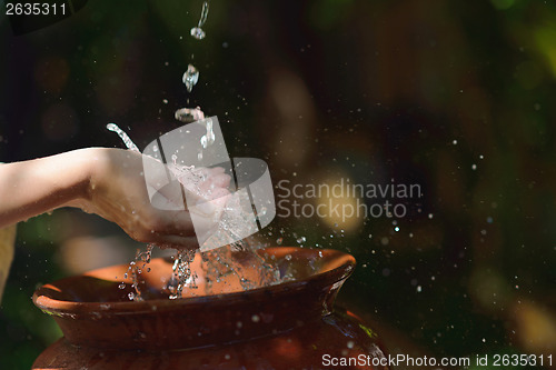 Image of splashing fresh water on woman hands