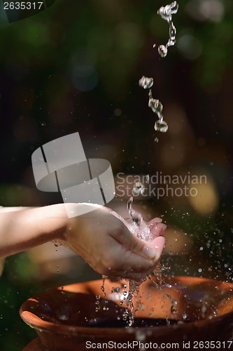 Image of splashing fresh water on woman hands