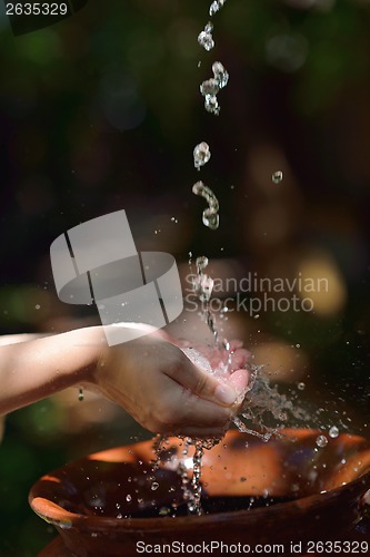 Image of splashing fresh water on woman hands