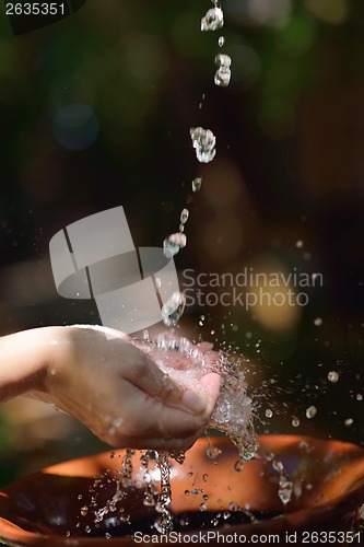 Image of splashing fresh water on woman hands