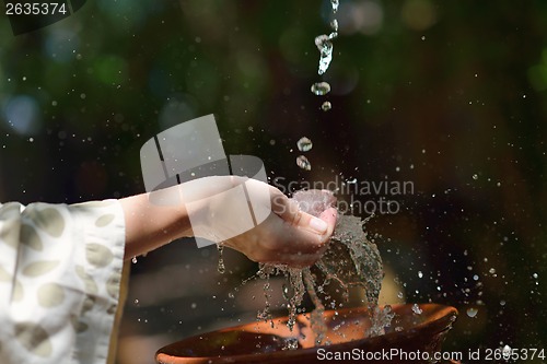 Image of splashing fresh water on woman hands