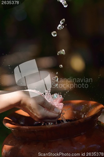 Image of splashing fresh water on woman hands