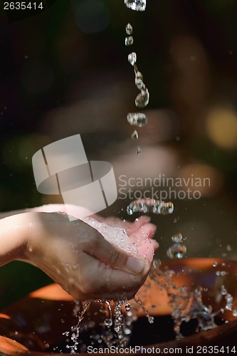 Image of splashing fresh water on woman hands