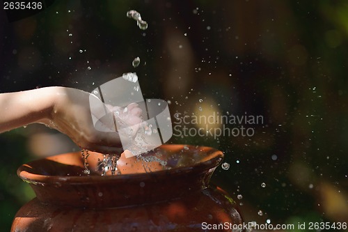 Image of splashing fresh water on woman hands