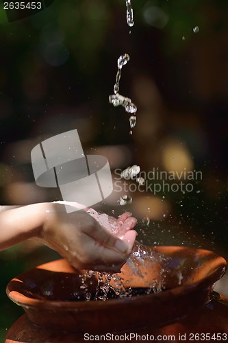 Image of splashing fresh water on woman hands