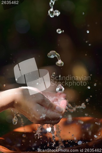 Image of splashing fresh water on woman hands