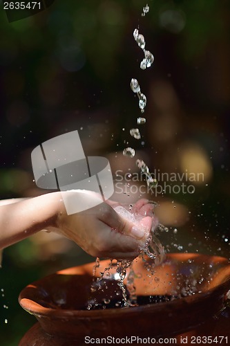 Image of splashing fresh water on woman hands