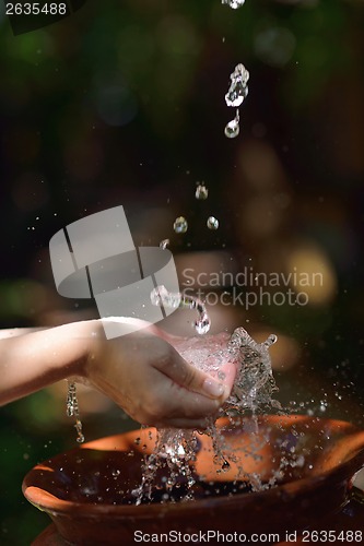 Image of splashing fresh water on woman hands