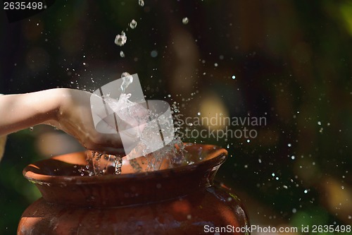 Image of splashing fresh water on woman hands