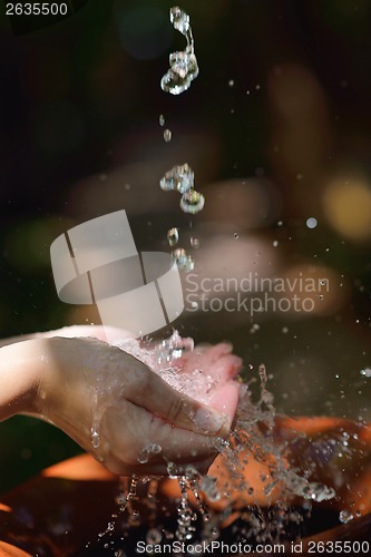 Image of splashing fresh water on woman hands