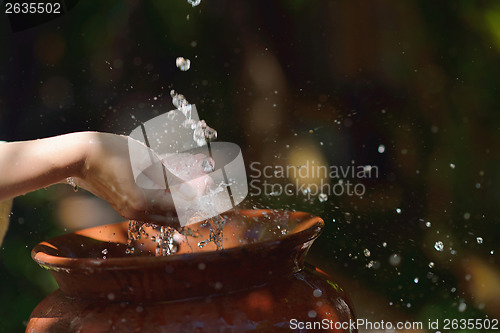 Image of splashing fresh water on woman hands