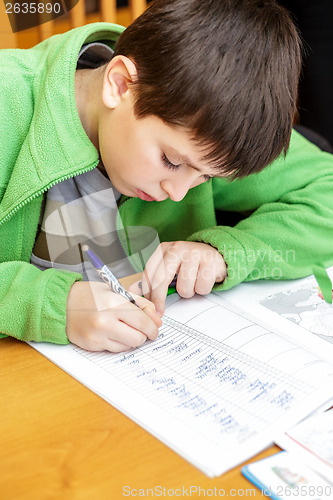 Image of bored and tired boy doing homework