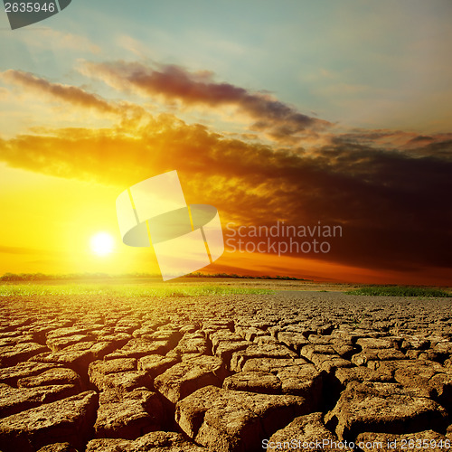 Image of dramatic sunset over drought earth