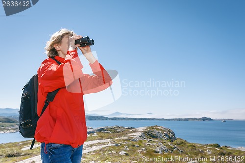 Image of Woman tourist looking through binoculars